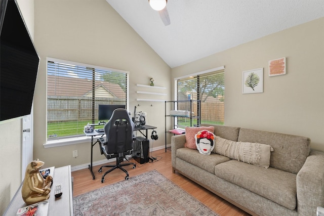 home office featuring baseboards, ceiling fan, high vaulted ceiling, and wood finished floors