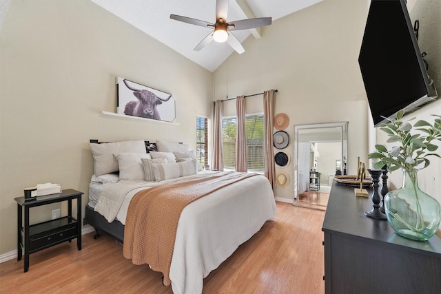 bedroom featuring light wood-style flooring, baseboards, ceiling fan, and high vaulted ceiling