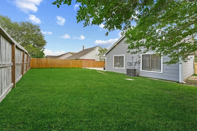 view of yard with a fenced backyard and central AC