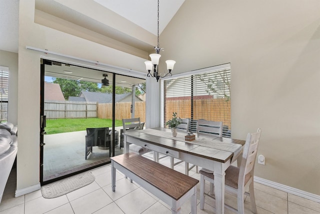 dining room featuring baseboards, a notable chandelier, light tile patterned floors, and high vaulted ceiling