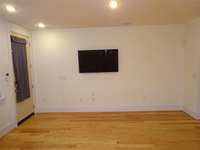 empty room with light wood-style floors, baseboards, and recessed lighting