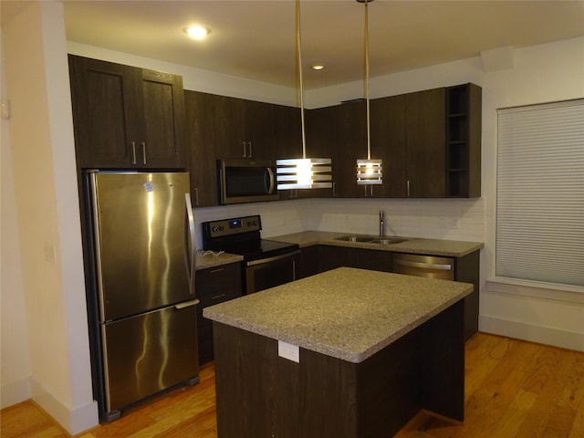 kitchen with a sink, dark brown cabinetry, open shelves, and appliances with stainless steel finishes