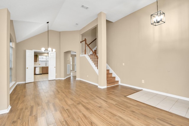 unfurnished living room featuring arched walkways, baseboards, visible vents, and light wood-type flooring