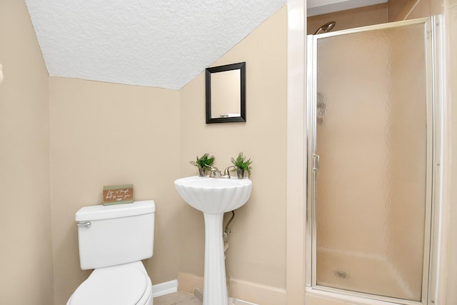 bathroom featuring toilet, a textured ceiling, tile patterned flooring, a shower stall, and lofted ceiling