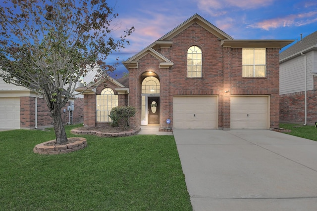 traditional-style house featuring a lawn, a garage, brick siding, and driveway