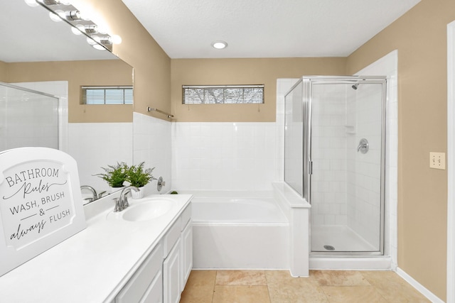 bathroom with a bath, vanity, and a stall shower