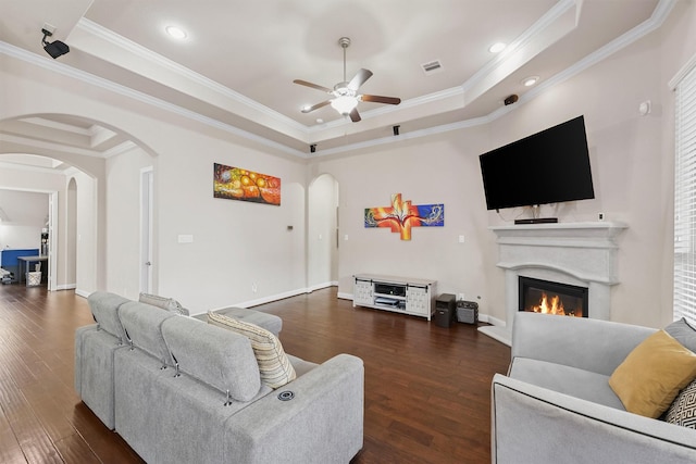 3743 Pinebrook Hollow Ln, Spring, TX 77386 - living room with a ceiling fan, visible vents, a raised ceiling, arched walkways, and a glass covered fireplace