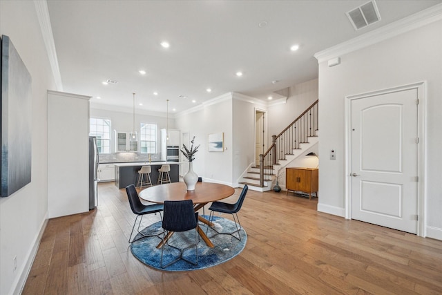 3606 Lannister Ln, Houston, TX 77055 - dining space featuring light wood-type flooring, stairway, crown molding, and recessed lighting