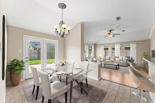 dining area with lofted ceiling, ceiling fan with notable chandelier, baseboards, and light tile patterned floors