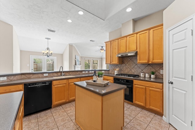 kitchen with a sink, dark countertops, black appliances, backsplash, and under cabinet range hood