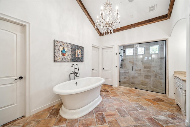 full bath with a stall shower, a notable chandelier, stone tile floors, a freestanding bath, and visible vents