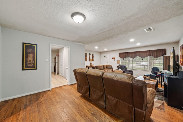 2310 Pecos St, La Marque, TX 77568 - living area featuring a textured ceiling, visible vents, baseboards, and light wood-style floors