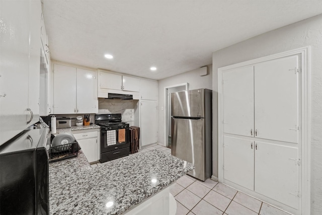 2310 Pecos St, La Marque, TX 77568 - kitchen featuring freestanding refrigerator, black range with gas cooktop, light tile patterned flooring, a peninsula, and white cabinets