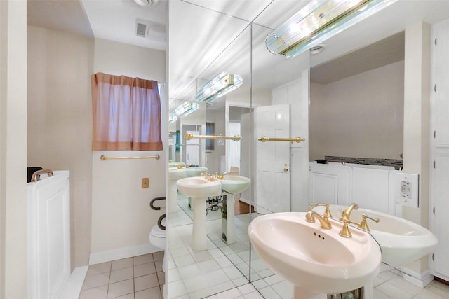 bathroom featuring a sink, tile patterned floors, and baseboards