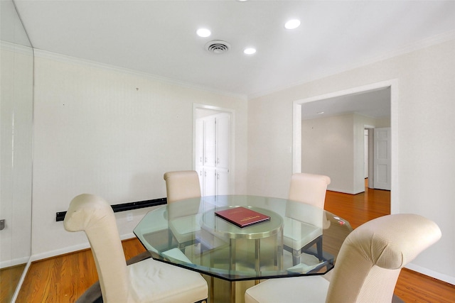 dining room with ornamental molding, wood finished floors, baseboards, and recessed lighting