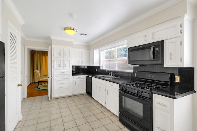 kitchen with black appliances, a sink, ornamental molding, dark countertops, and white cabinets