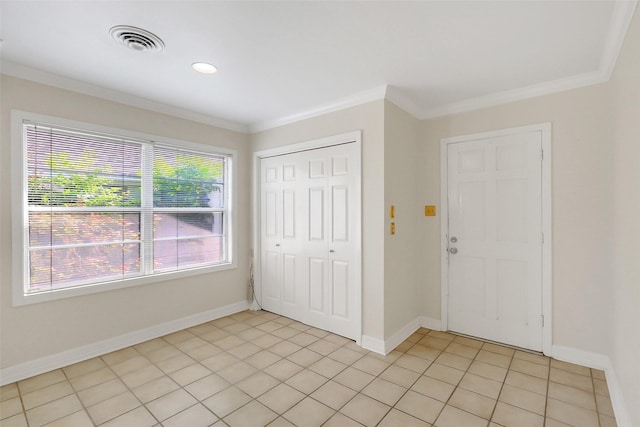 unfurnished bedroom with crown molding, a closet, and baseboards