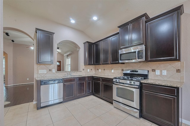 3603 Canvasback Ln, Houston, TX 77047 - kitchen with stainless steel appliances, arched walkways, lofted ceiling, decorative backsplash, and a sink