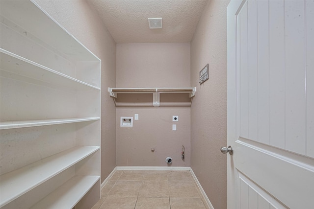 3603 Canvasback Ln, Houston, TX 77047 - laundry area with electric dryer hookup, hookup for a washing machine, tile patterned floors, a textured ceiling, and gas dryer hookup