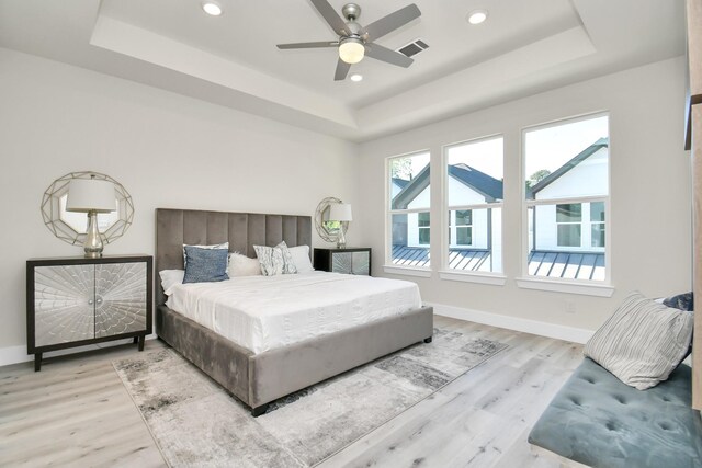 6553 Sealey St, Houston, TX 77091 - bedroom with wood finished floors, a tray ceiling, visible vents, baseboards, and recessed lighting