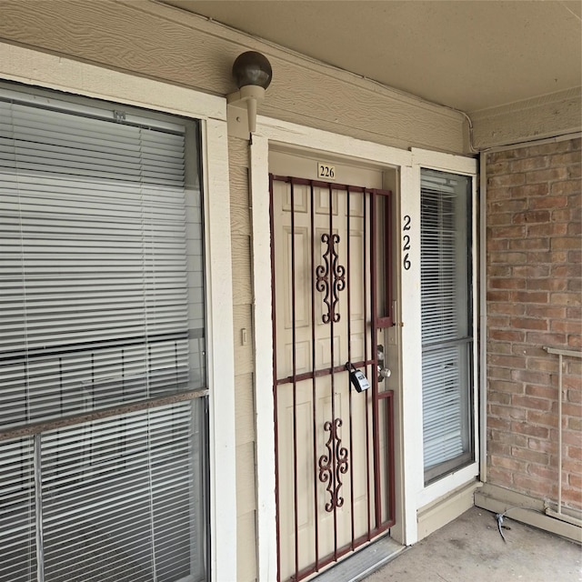 view of exterior entry featuring brick siding