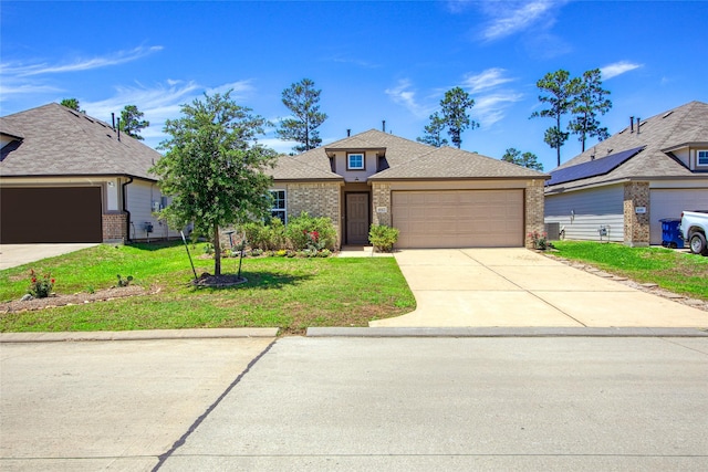 view of front of house featuring a garage, concrete driveway, a front yard, brick siding, and roof with shingles