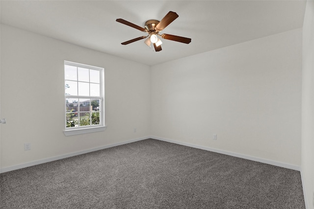 carpeted empty room featuring baseboards and a ceiling fan