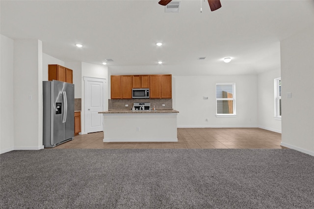 kitchen featuring a ceiling fan, light tile patterned floors, open floor plan, light carpet, and appliances with stainless steel finishes