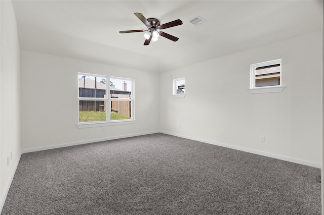 empty room with carpet flooring, visible vents, baseboards, and ceiling fan