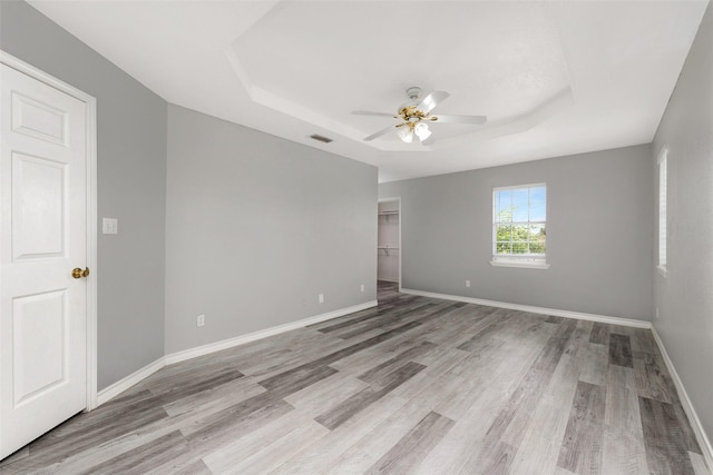 701 Briar Ct, Brownsville, TX 78521 - empty room featuring a tray ceiling, a ceiling fan, and wood finished floors