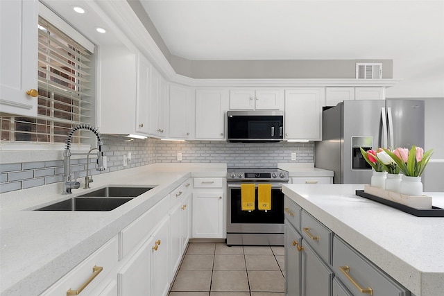 701 Briar Ct, Brownsville, TX 78521 - kitchen with a sink, stainless steel appliances, visible vents, tasteful backsplash, and light tile patterned flooring