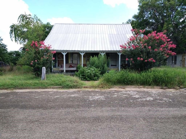 view of front facade with covered porch and metal roof