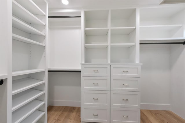 walk in closet with light wood-style floors
