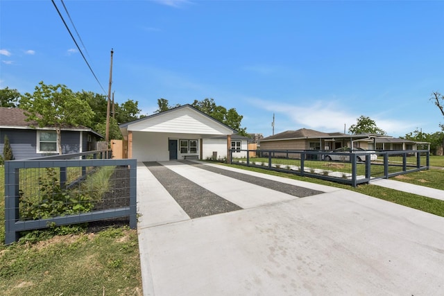view of front of home with concrete driveway and fence