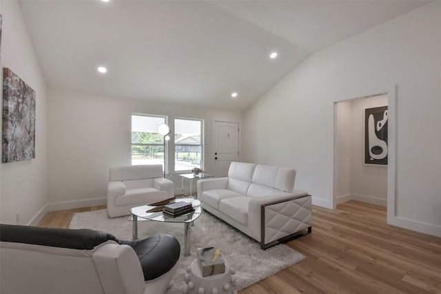 living area featuring vaulted ceiling, wood finished floors, baseboards, and recessed lighting