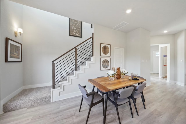 dining room with light wood finished floors, recessed lighting, visible vents, baseboards, and stairs
