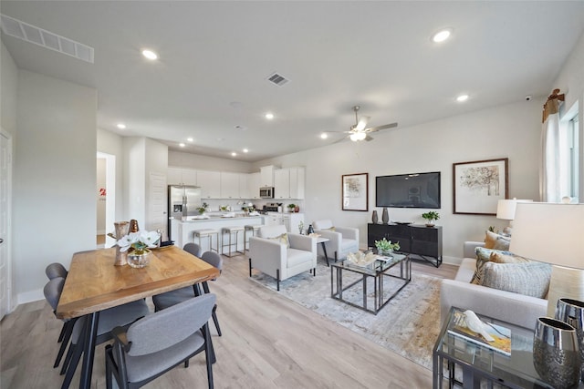 living area featuring ceiling fan, light wood-type flooring, visible vents, and recessed lighting