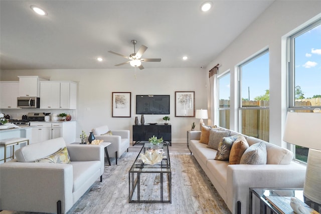 living room featuring light wood finished floors, recessed lighting, and plenty of natural light