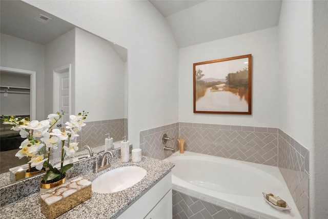 full bathroom with vanity, visible vents, and a bath