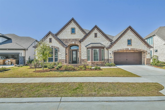 11131 Heartleaf Aster Way, Cypress, TX 77433 - french country inspired facade featuring concrete driveway, stone siding, brick siding, and a front yard