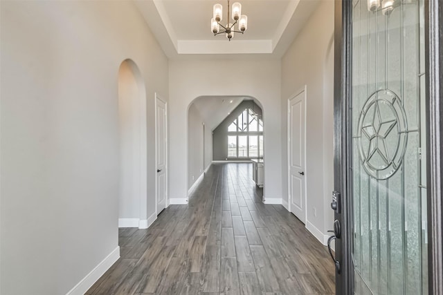 11131 Heartleaf Aster Way, Cypress, TX 77433 - entrance foyer with an inviting chandelier, baseboards, a raised ceiling, arched walkways, and dark wood-style floors