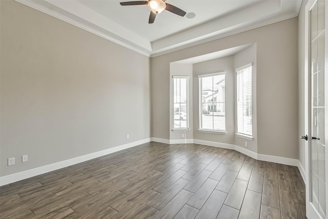 11131 Heartleaf Aster Way, Cypress, TX 77433 - spare room featuring a tray ceiling, ceiling fan, baseboards, and dark wood finished floors
