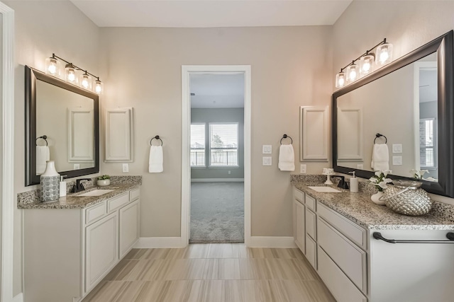 11131 Heartleaf Aster Way, Cypress, TX 77433 - bathroom featuring baseboards, two vanities, and a sink