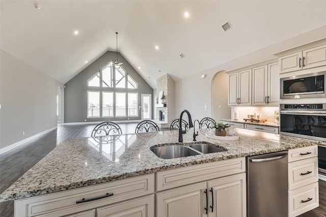11131 Heartleaf Aster Way, Cypress, TX 77433 - kitchen featuring a sink, stainless steel appliances, visible vents, vaulted ceiling, and open floor plan