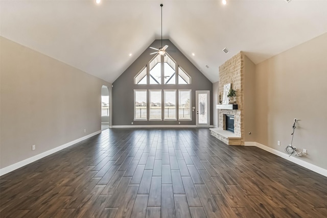 11131 Heartleaf Aster Way, Cypress, TX 77433 - unfurnished living room with a ceiling fan, a fireplace, baseboards, arched walkways, and dark wood-style floors