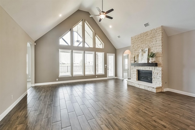 11131 Heartleaf Aster Way, Cypress, TX 77433 - unfurnished living room featuring arched walkways, a stone fireplace, visible vents, and ceiling fan