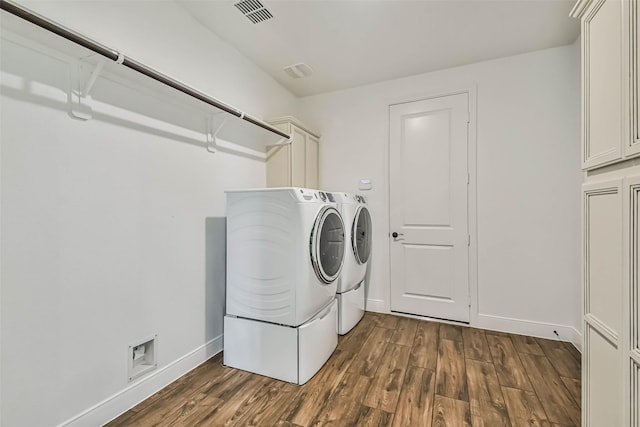 11131 Heartleaf Aster Way, Cypress, TX 77433 - clothes washing area with washer and dryer, cabinet space, dark wood finished floors, visible vents, and baseboards