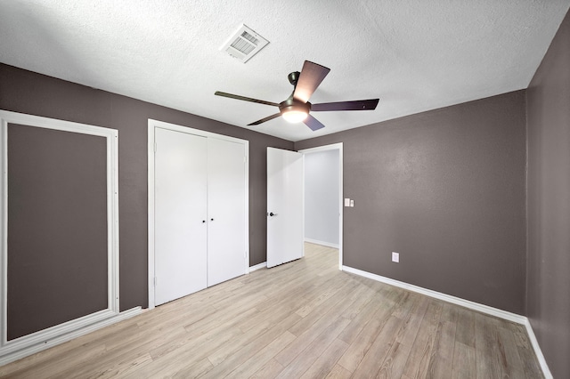 315 Lakeview Hbr, Onalaska, TX 77360 - unfurnished bedroom with light wood-style floors, a closet, baseboards, a textured ceiling, and ceiling fan