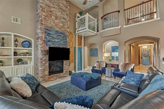 19089 Grandview Pt, Montgomery, TX 77356 - living room with arched walkways, a towering ceiling, a ceiling fan, and a stone fireplace