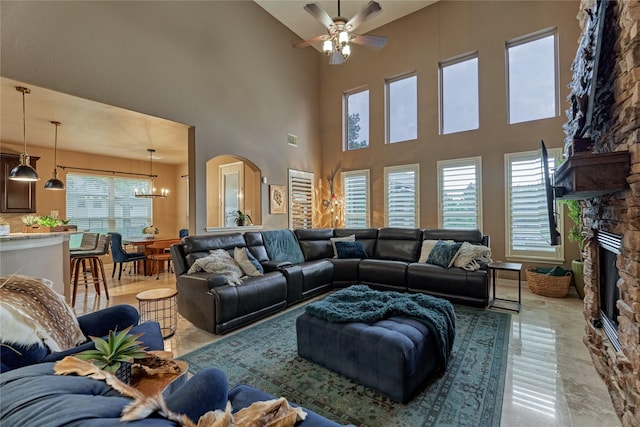 19089 Grandview Pt, Montgomery, TX 77356 - living area with a high ceiling, a ceiling fan, a fireplace, a chandelier, and arched walkways